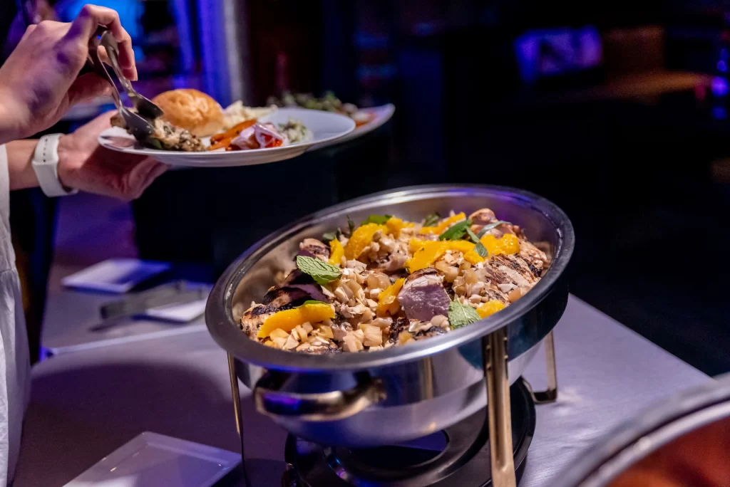 sri lankan / south indian food placed in a buffet table and a man taking the food in his table